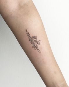 a woman's arm with a flower tattoo on the left side of her arm