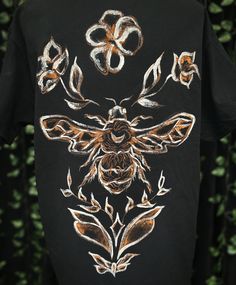 a black t - shirt with an image of a bee on it