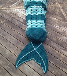 a knitted mermaid tail laying on top of a wooden floor