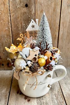 a cup filled with christmas decorations on top of a wooden table