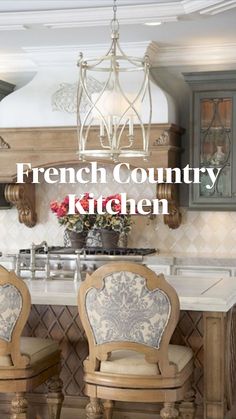 two chairs sitting in front of a kitchen island with marble counter tops and an ornate chandelier