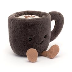 a coffee mug with a wooden spoon in it and a brown teddy bear on the side