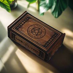 a wooden box sitting on top of a table next to a potted green plant