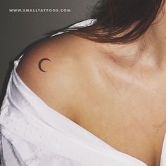 a woman with a small crescent tattoo on her left shoulder and right arm behind her neck