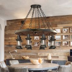 a chandelier hanging from the ceiling in a dining room with pictures on the wall