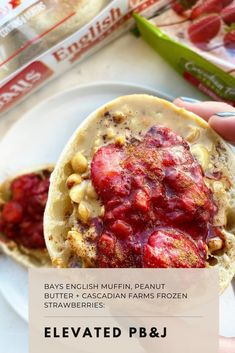 a person holding up a piece of bread with strawberries on it and the caption says, bay's english muffin peanut strawberry staw