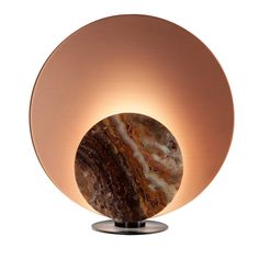 a marble ball on a metal stand with a light in the middle that is turned on