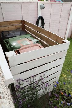 a wooden crate filled with lots of stuff next to a flower potted planter