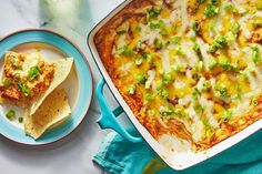 a casserole dish with tortilla chips on the side and a bowl of salsa next to it