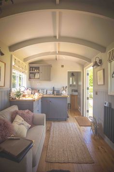 a living room filled with furniture next to a kitchen and breakfast nook on top of a hard wood floor