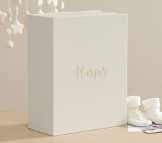 a white box with the word harper written on it next to some baby shoes and flowers