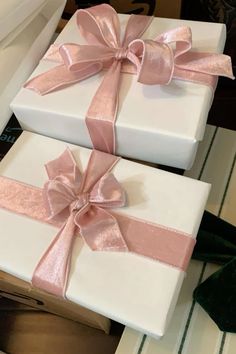 two white boxes with pink bows on them