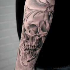 a man's arm with a skull and rose tattoo on it