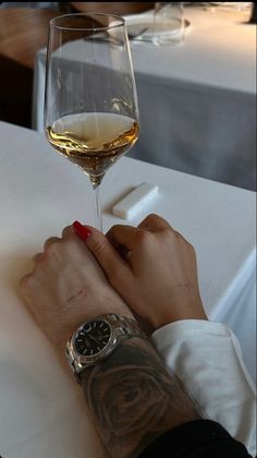 a person holding onto a glass of wine