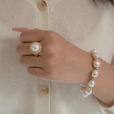 This classic ring is made with our signature 12-13mm AA perfect round white Edison Pearl. The pearl is in perfect round shape with very high quality of luster. Surrounded by a circle of small pieces of zircons on 14k gold vermeil band. Pearl Type: Freshwater Edison Pearls Pearl Quality: AA [Shape]: Round Pearl [Pearl Size]: 12-13mm [Blemish]: Minimal [Luster]: Relatively High Ring Size: Open ended adjusted from 6 to 8 (US/Canada sizing) Metal material: 14k Gold Vermeil Note: Every pearl is uniqu Luxury Round Pearl Drop Ring, Luxury Round Ring With Pearl Drop, Luxury Pearl White Round Pearl Ring, Luxury Round Pearl White Ring, Timeless White Pearl Ring, Elegant White Oval Dome Ring, Pearl Drop Diamond Ring, Elegant 14k Gold Round Pearl Ring, Elegant 14k Gold Pearl Ring