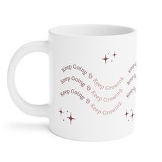 a white coffee mug with the words keep going and keep growing in pink on it