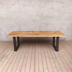 a wooden table sitting on top of a hard wood floor next to a white wall