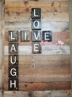 the word live laugh laugh spelled in scrabble letters on wood planks with words that spell out love and laugh