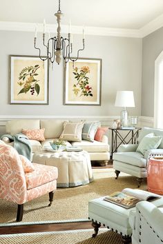 a living room filled with furniture and a chandelier hanging above the couches