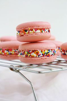 pink macaroons with sprinkles on a cooling rack