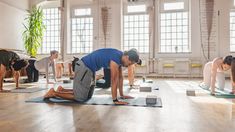 a group of people doing yoga in a room