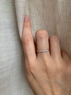 a woman's hand with a diamond ring on her left hand and the other hand holding