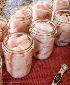 several jars filled with food sitting on top of a table next to a spoon and knife