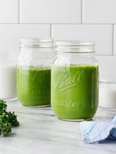 two mason jars filled with green smoothie