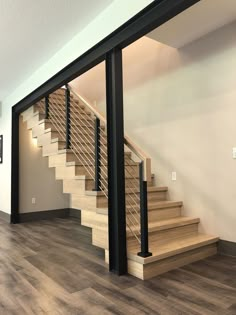 an empty living room with stairs leading up to the second floor