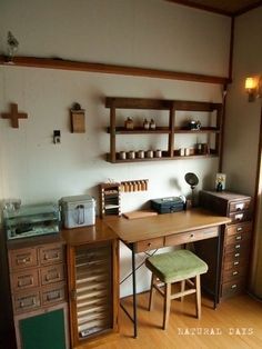 a wooden desk sitting in the middle of a room next to a wall mounted shelf