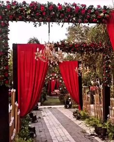 an outdoor ceremony with red curtains and flowers