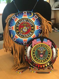 two round beaded purses sitting on top of a wooden table next to a black mannequin