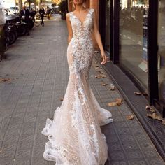 a woman is walking down the street wearing a wedding dress