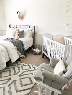 a baby's room with two cribs, a rocking chair and a bed