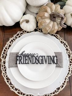 a white plate topped with a happy thanksgiving sign next to some pumpkins and gourds