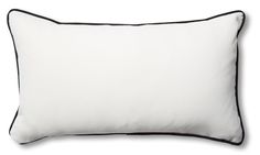 a white pillow with black piping on the front and back side, against a white background