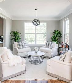 a living room filled with white furniture and lots of windows