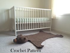 a crochet teddy bear rug on the floor next to a white crib