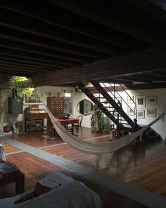 a living room filled with furniture and a hammock in the middle of it