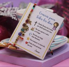 a card with some charms on it sitting in front of other ornaments and decorations,