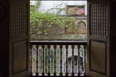 an open door to a balcony with a view of the street and building through it