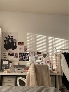 a bed room with a neatly made bed and lots of pictures on the wall above it