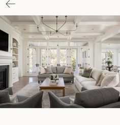 a living room filled with furniture and a flat screen tv mounted to the wall over a fireplace