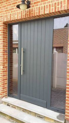 the front door to a brick building with glass doors and steps leading up to it