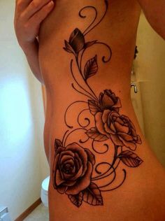 a woman's lower back tattoo with roses on it