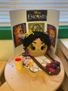 a child's head sitting on top of a wooden table next to a toy guitar