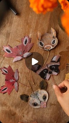 someone is making some paper flowers out of leaves and other things on the wooden table