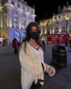 a woman walking down the street wearing a face mask