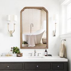 a bathroom with a sink, mirror and bathtub in the middle of it's wall