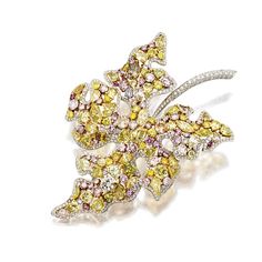 COLOURED DIAMOND AND DIAMOND 'LEAF' BROOCH. The stylised leaf decorated with a cluster of variously-shaped coloured diamonds, supported by a frame and stem pavé-set with brilliant-cut diamonds, the diamonds together weighing approximately 28.35 carats, mounted in 18 karat white and yellow gold. Coloured Diamonds, Titanic Jewelry, Jewelry Design Drawing, Leaf Brooch, Autumn Colors, Fantasy Jewelry, Fancy Color Diamonds